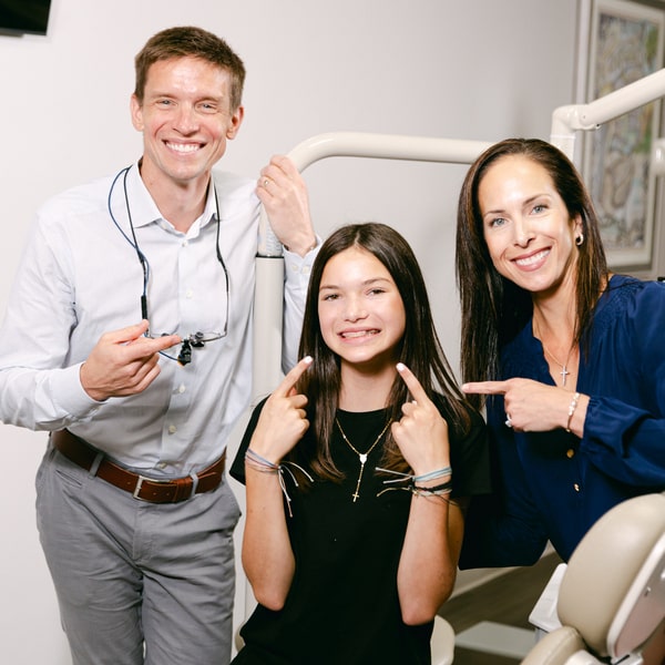 Dr. McEntire is smiling together with his happy patient and her mother