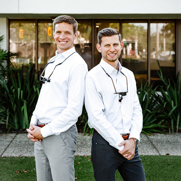 Trusted Orthodontics in St. Petersburg & Tampa: Personalized Care, Cutting-Edge Technology. Dr. Rick Escobar and Dr. Clayton McEntire are joyfully smiling at Amley McEntire Orthodontics