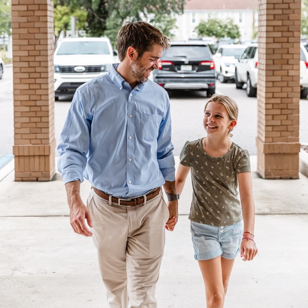 Happy smiling father and daughter entering Amley McEntire ortho office