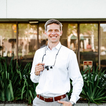 Dr. Clayton McEntire is smiling in front of a dentistry building