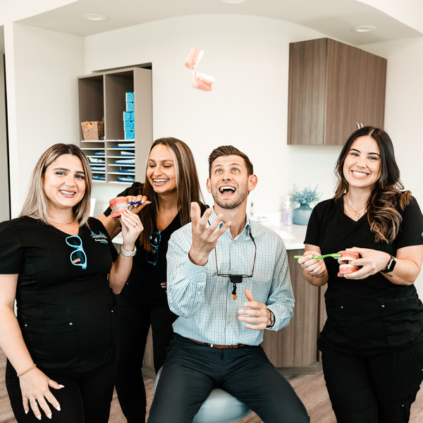 Trusted Orthodontic Care: Partner with Amley McEntire Orthodontics for Seamless Patient Referrals. Dr Escobar with his team all smiling and having fun